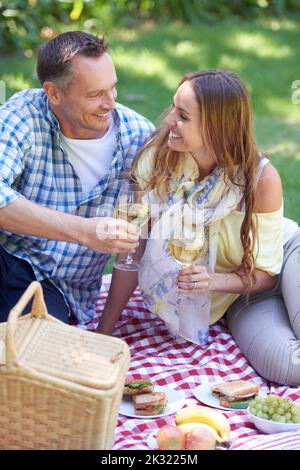 Es gibt nichts Romantischeres als ein Picknick. Ein Ehepaar genießt ein Picknick im Freien. Stockfoto