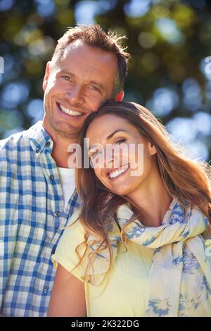 Ihre Liebe scheint hell. Porträt eines liebevollen Paares draußen in der Sommersonne. Stockfoto