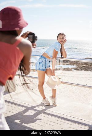 Strand, Modell und Fotoshooting mit einer Frau draußen auf der Promenade für ein Foto mit dem Meer, Meer oder schönen Blick auf den Strand. Mode, Fotograf Stockfoto