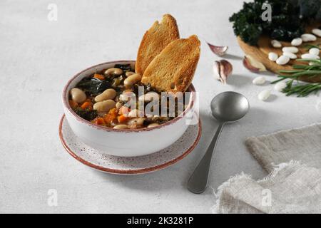 Wintersuppe mit verschiedenen Gemüsesorten, Bohnen, Grünkohl, direkt darüber. Typisch toskanische Suppe, Ribollita. Italienisches Komfort-Essen. Kopierraum Stockfoto