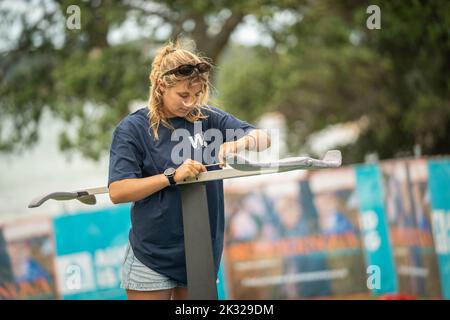 Eine junge Teilnehmerin stellt ihre Ausrüstung auf, um beim Watersports Festival in Waterbourne am nationalen neuseeländischen Windsurf-Tragflächenboot-Rennen teilzunehmen Stockfoto