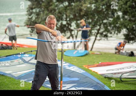 Die Teilnehmer stellen ihre Ausrüstung auf, um beim Waterbourne Watersports Festival an dem neuseeländischen nationalen Windsurf-Tragflächenboot-Rennen teilzunehmen Stockfoto