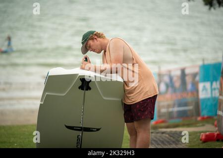 Die Teilnehmer stellen ihre Ausrüstung auf, um beim Waterbourne Watersports Festival, Takapuna, an dem neuseeländischen nationalen Windsurf-Hydrofoil-Rennen teilzunehmen. Stockfoto