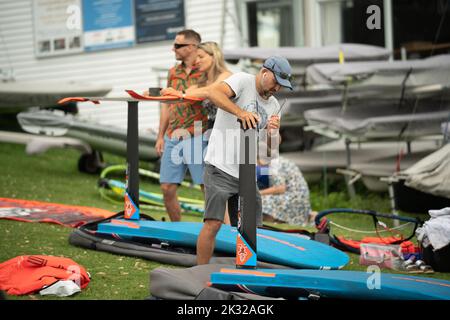 Die Teilnehmer stellen ihre Ausrüstung auf, um beim Waterbourne Watersports Festival an dem neuseeländischen nationalen Windsurf-Tragflächenboot-Rennen teilzunehmen Stockfoto