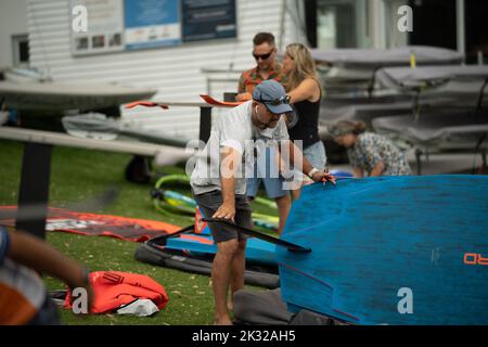 Die Teilnehmer stellen ihre Ausrüstung auf, um beim Waterbourne Watersports Festival an dem neuseeländischen nationalen Windsurf-Tragflächenboot-Rennen teilzunehmen Stockfoto