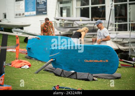 Die Teilnehmer stellen ihre Ausrüstung auf, um beim Waterbourne Watersports Festival an dem neuseeländischen nationalen Windsurf-Tragflächenboot-Rennen teilzunehmen Stockfoto