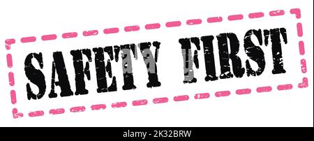 SICHERHEIT ERSTER Text auf rosa-schwarz gestrichelte Stempelschild geschrieben. Stockfoto