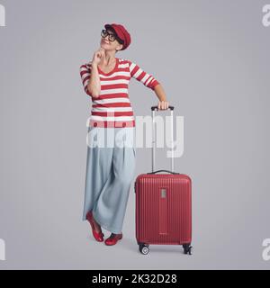 Glückliche Reisende Frau denken mit Hand auf Kinn, Reise-und Chancen-Konzept Stockfoto