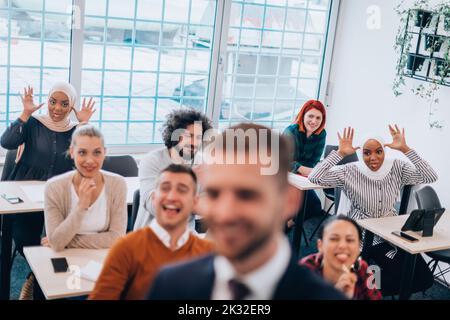 Ein junges, vielfältiges Team von Menschen, die lachen und Spaß in einer Trainingseinheit haben Stockfoto