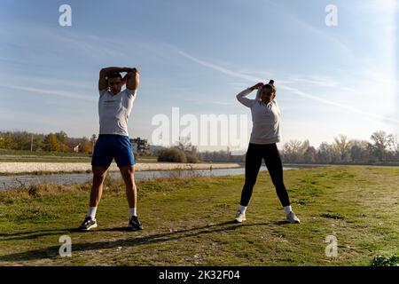 Zwei tolle und attraktive Fit-Freunde trainieren gemeinsam und dehnen sich Stockfoto