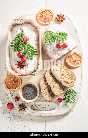Hausgemachter Mohnkuchen mit Fichtenornamenten zu Weihnachten auf weißem Brett Stockfoto