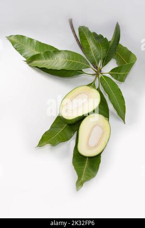 Scheiben roher grüner Mango auf Blättern. Stockfoto