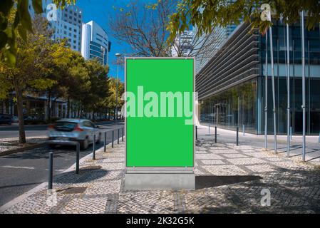 Leere Plakatwand mit einem grünen Bildschirm auf der Straße mit modernen Gebäuden Stockfoto