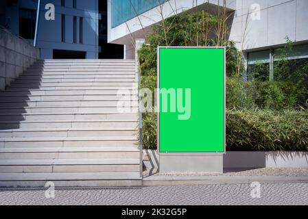 Vertikales Billboard-Modell mit grünem Bildschirm in der Straße neben der Treppe Stockfoto