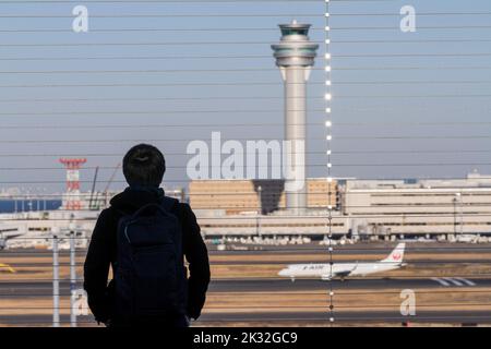 Ein Mann beobachtet, wie Verkehrsflugzeuge auf der Aussichtsplattform des Haneda International Airport, Tokio, starten und landen. Stockfoto