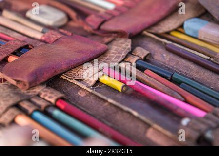 Nahaufnahme von alten Zeichenstiften in Ledertasche auf einem Flohmarkt in der Provence Stockfoto