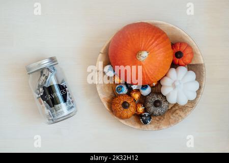 Sparen Sie Geld Halloween, Ersparnisse, Halloween auf Budget. Glas Einmachglas Sparschwein mit Dollar Bargeld auf Halloween Kürbis Dekoration Hintergrund Stockfoto