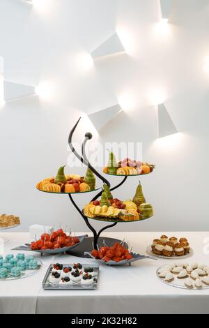 Wunderschön servierte Tafel mit Früchten und Süßigkeiten. Stockfoto