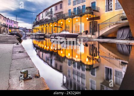 Malerischer Blick auf Port Grimaud bei Nacht im Herbst, der das Kanalwasser vor dem dramatischen Herbsthimmel reflektiert Stockfoto