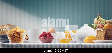 Köstliches gesundes Frühstück zu Hause mit frischem Obst, Müsli, Tee und Brot Stockfoto