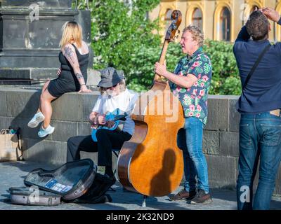 Prag, Tschechische Republik - Juni 2022: Straßenkünstler spielen Gitarre und Cello für Touristen auf der Karlsbrücke, Prag. Stockfoto