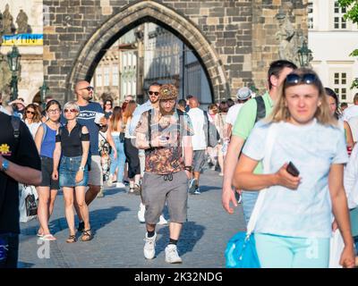 Prag, Tschechische Republik - 2022. Juni: Massen von Touristen, die auf der berühmten Karlsbrücke in Prag spazieren und spazieren gehen. Stockfoto