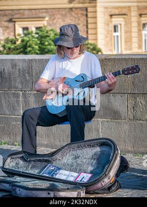 Prag, Tschechische Republik - Juni 2022: Straßenkünstler spielen auf der Karlsbrücke in Prag Gitarre für Touristen. Stockfoto