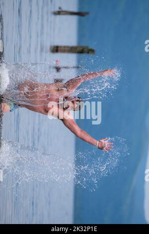 Die Menschen genießen den Sommer in Luss am Loch Lomond, Schottland, beim Springen und Schwimmen im kalten, frischen Wasser des loch. Stockfoto