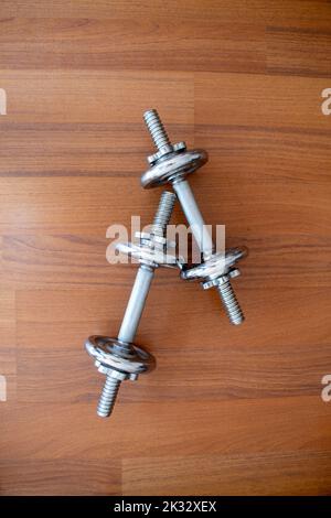Metallhanteln auf dem Boden, isolierter Holzhintergrund, selektiver Fokus Stockfoto