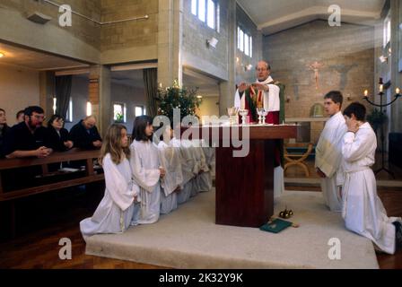 Priester mit Händen über Altar in der Kommunion St. Bernard's Church Lingfield Stockfoto