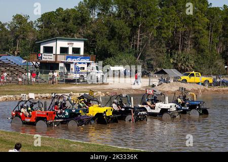 Sumpfbuggys aufgereiht, im Wasser, Startrennen, Fahrzeugsport, schnell, Teilnehmer tragen Helme, Jeeps, Zuschauer, Florida Sports Park, Naples, FL Stockfoto