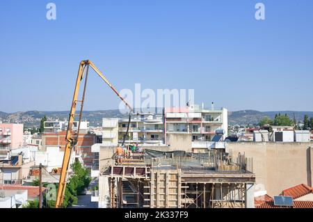 Die Bauarbeiter gießen frischen feuchten Zement auf den Boden des Fundaments eines Wohnungsgebäudes Stockfoto