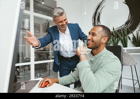 Zwei multiethnische Kollegen aus der Wirtschaft arbeiten in einem modernen Büro zusammen Stockfoto