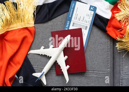 Nationale VAE, US-Flaggen, Spielzeugflugzeug und Pässe auf grauem Hintergrund Stockfoto