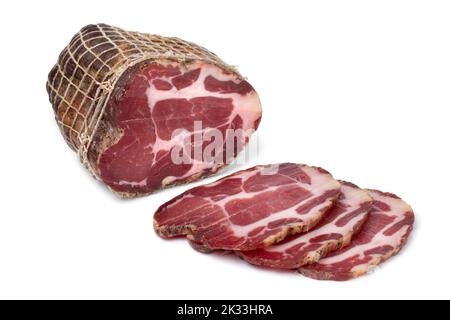 Stück und Scheiben des traditionellen kroatischen getrockneten Schweinehals, Schweinekragen Speck, aus der Nähe isoliert auf weißem Hintergrund Stockfoto