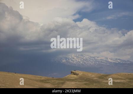 Hinter den Wolken Mount Ararat, ein paar Silhouetten von Menschen auf dem Hügel vor Stockfoto