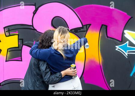 Birmingham, Großbritannien. 24. September 2022. „Zest“ und „OK“ teilen sich eine Wand als zwei von etwa einem Dutzend Straßengraffiti-Künstlerinnen, die im Rahmen des High Vis Street Art Festivals bei den Tea Works an Wänden in Digbeth arbeiten. Street Art wird oft als männlich dominierte Kultur angesehen, aber das ändert sich. Kredit: Peter Lopeman/Alamy Live Nachrichten Stockfoto