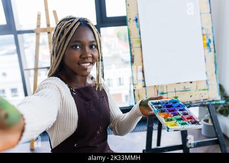 brasilianische Frau mit Dreadlocks in weißer Bluse im Kunststudio Stockfoto