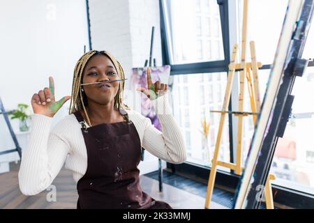 Junge afrikanische Studentin mit Nasenpiercing im Kunststudio Stockfoto