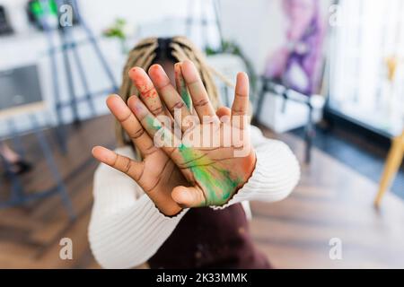 brasilianische Frau mit Dreadlocks in weißer Bluse im Kunststudio Stockfoto