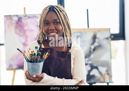 Junge afrikanische Studentin mit Nasenpiercing im Kunststudio Stockfoto