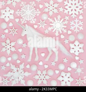 Mythisches Weihnachts-Einhorn, Schneeflocke und Baumkugeln. Fantasy Nordpol rosa Hintergrund-Design für Winter, Weihnachten und Neujahr Weihnachtszeit. Stockfoto