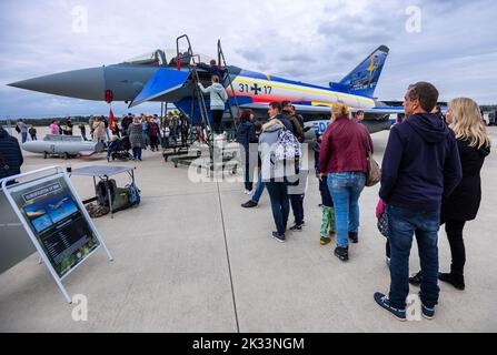 Laage, Deutschland. 24. September 2022. Beim Flughafenfest stehen die Besucher vor einem Eurofighter, der anlässlich des 25.-jährigen Jubiläums der Jagdgeschwader in einer speziellen Farbgebung gestrichen wurde, um von einer Leiter aus einen Blick in das Cockpit des Piloten zu werfen. Mehr als 10.000 Menschen nahmen am Flughafenfest Teil und konnten damit einen neuen Besucherrekord für das Ereignis nach der Pandemiepause verzeichnen. Der neue Flughafenbetreiber, die Zeitfracht Group, gab einen Einblick in die Pläne des Flughafens rund um die Luftfahrt. Quelle: Jens Büttner/dpa/Alamy Live News Stockfoto