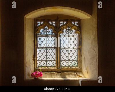 Kirchenfenster mit Blumen in der St. Thomas a Beckett Church in Capel, Kent. Stockfoto