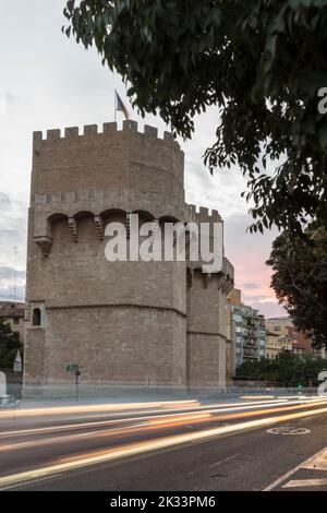 Seitenansicht von Torres de Serrano, Blick von der Straße in der Dämmerung, Lichter der vorbeifahrenden Fahrzeuge, Valencia, Spanien Stockfoto