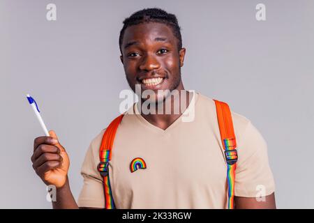 hispanischer Student Mann mit Regenbogenabzeichen auf T-Shirt im Studio Isolate Stockfoto