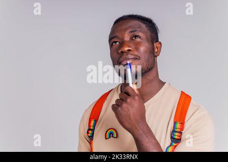 hispanischer Student Mann mit Regenbogenabzeichen auf T-Shirt im Studio Isolate Stockfoto