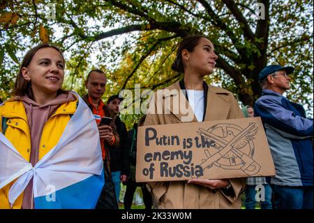 Den Haag, Niederlande. 24. September 2022. Während der Demonstration wird eine Frau mit einem Plakat gegen Putin gesehen. Vor der russischen Botschaft in Den Haag organisierte die russische Gemeinschaft in den Niederlanden einen Protest gegen das Dekret von Präsident Wladimir Putin, teilweise Reservisten in Russland zu mobilisieren, und gegen den Krieg in der Ukraine. Trotz der harten Gesetze Russlands gegen die Kritik am Militär und am Krieg fanden im ganzen Land Proteste statt. Mehr als 1.300 Russen wurden bei Antikriegsdemonstrationen in 38 Städten verhaftet. Kredit: SOPA Images Limited/Alamy Live Nachrichten Stockfoto