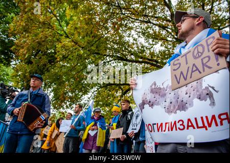 Den Haag, Niederlande. 24. September 2022. Während der Demonstration werden russische Demonstranten die ukrainische Nationalhymne singen sehen. Vor der russischen Botschaft in Den Haag organisierte die russische Gemeinschaft in den Niederlanden einen Protest gegen das Dekret von Präsident Wladimir Putin, teilweise Reservisten in Russland zu mobilisieren, und gegen den Krieg in der Ukraine. Trotz der harten Gesetze Russlands gegen die Kritik am Militär und am Krieg fanden im ganzen Land Proteste statt. Mehr als 1.300 Russen wurden bei Antikriegsdemonstrationen in 38 Städten verhaftet. Kredit: SOPA Images Limited/Alamy Live Nachrichten Stockfoto