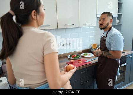 Asiatisches Paar, das gemeinsam in der Küche Frühstück kocht Stockfoto